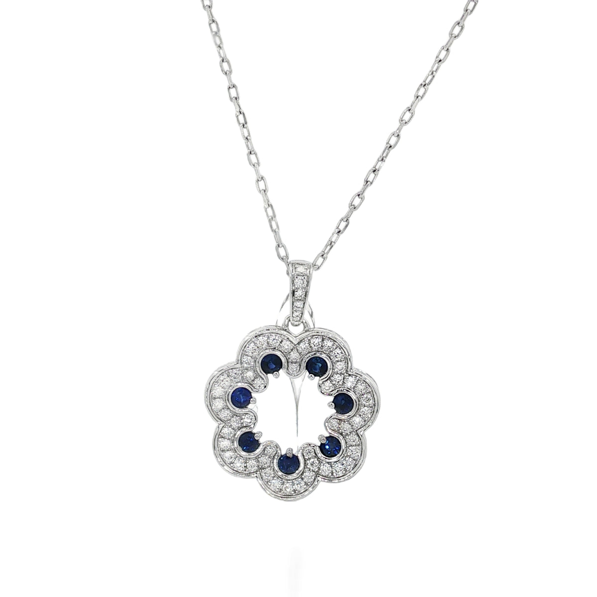 White gold scalloped flower pendant with blue sapphires and diamond borders