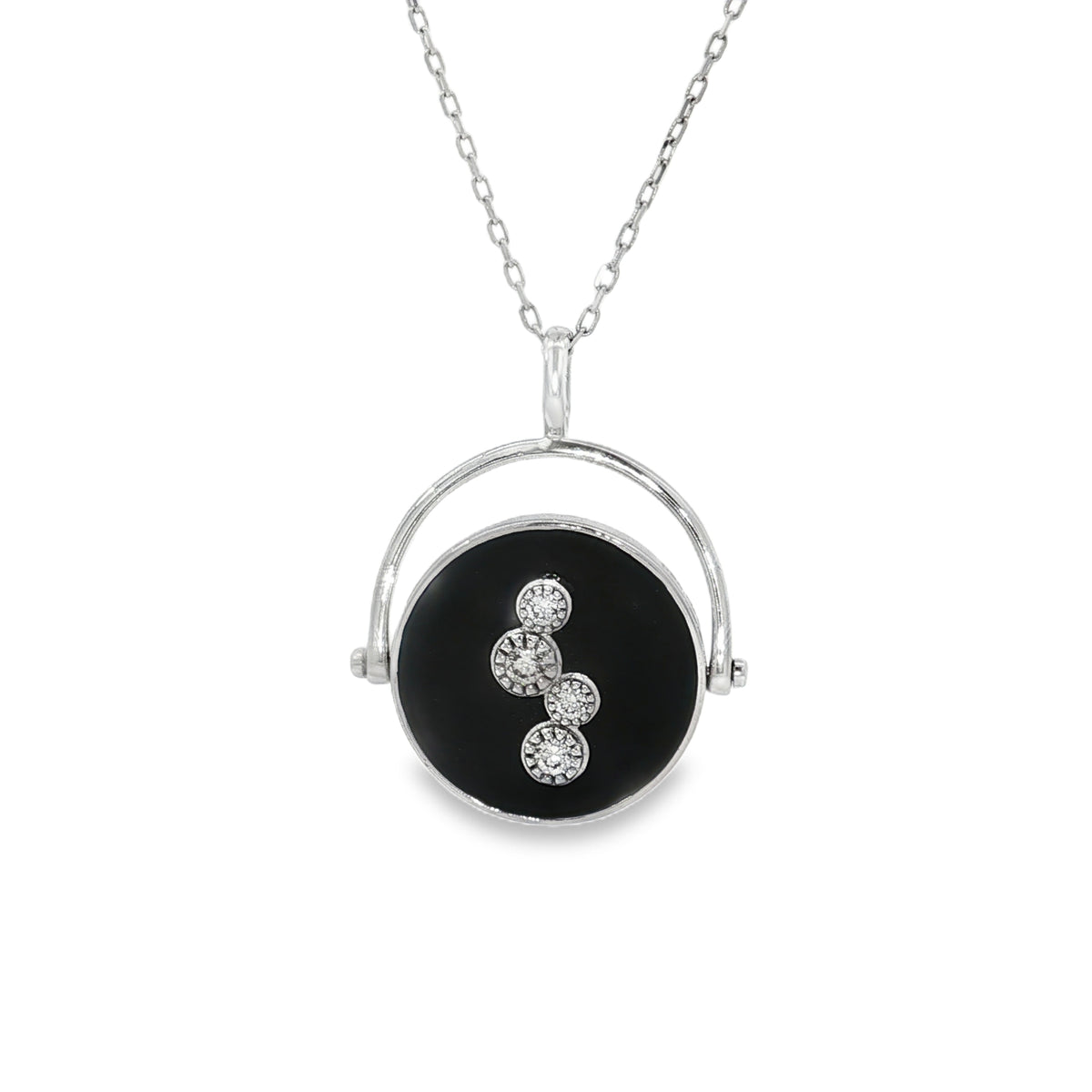 White gold necklace with black disc, circular frame and four diamond clusters