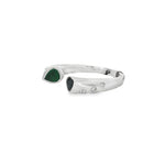 Angled view of emerald and sapphire teardrop ring showing offset ends and smooth inner band