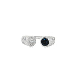 White gold open ring with round sapphire opposite a baguette and round diamond medallion