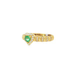 Angled view of emerald heart, diamond halo and detailed yellow gold band