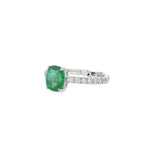 Angled view of oval emerald setting and diamond-lined white gold band