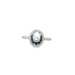 White gold open-oval ring with sapphire crescent inside a diamond border