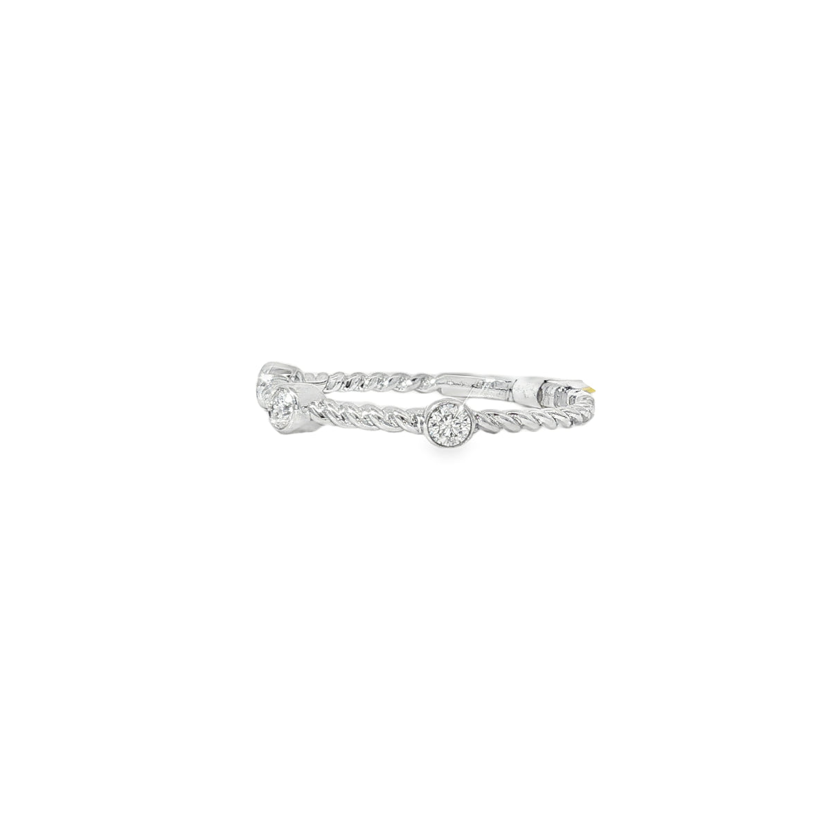 Angled view of white gold ring showing twisted texture between diamond bezels